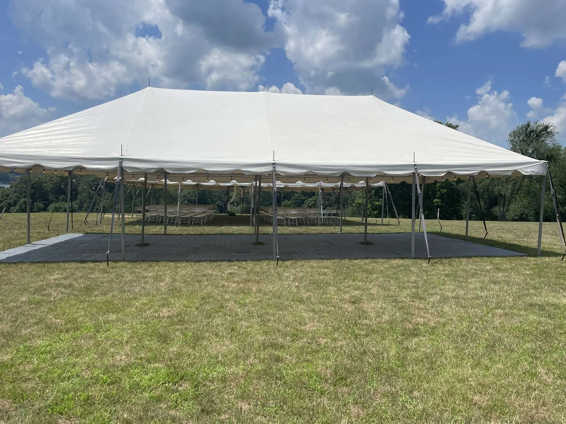 Large white event tent on a summer lawn